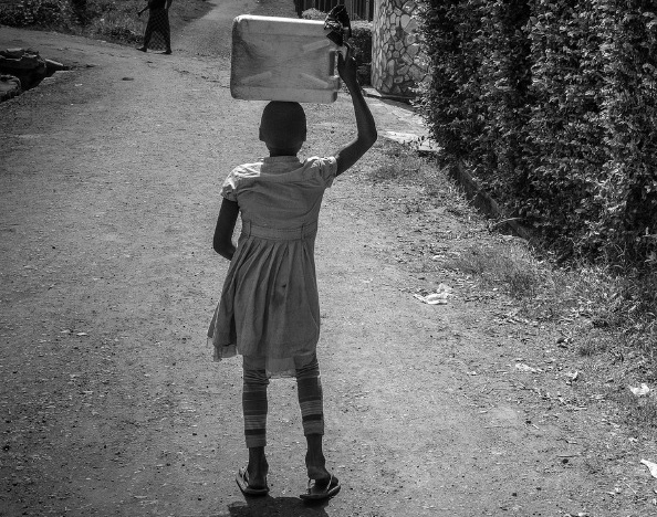 child carrying a canister on her head